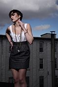 fashion model posing with buildings in background in dramatic lighting
