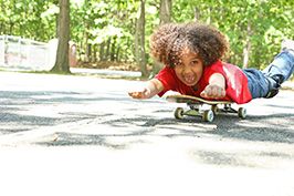 little boy skateboarding in park